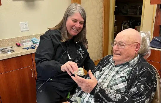 Dr. Trembath helping an elderly patient with dental care